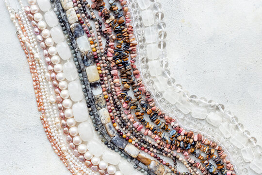 A pile of gemstones and pearls beads for jewelry, top view, flat lay