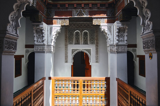 Interior view of a traditional Moroccan riad with ornate plasterwork and wooden balcony