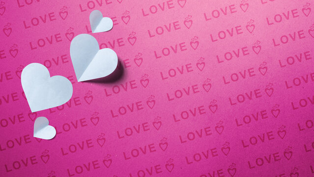 Paper white hearts on pink background with love text for Valentines day greeting card. Love background