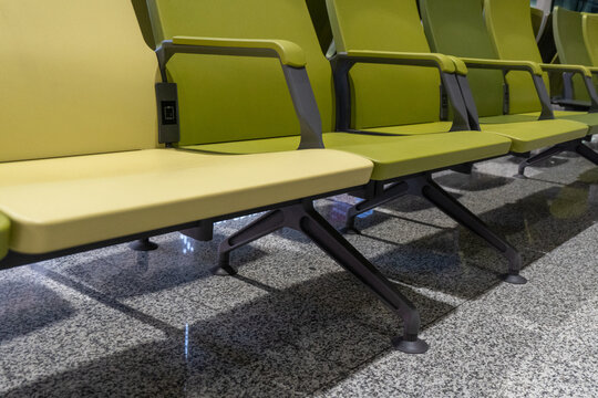 Empty green seats arranged on glossy floor