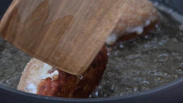 Video of breaded Cordon Bleu schnitzels filled with melted cheese frying