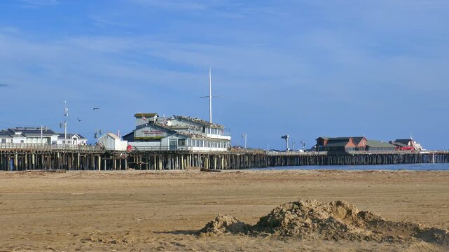 Santa Barbara, California, 2024. Sunny beach, recreationists and tourists walk the pier and enjoy the beautiful weather. Restaurant, shops and businesses at Stearns Wharf.