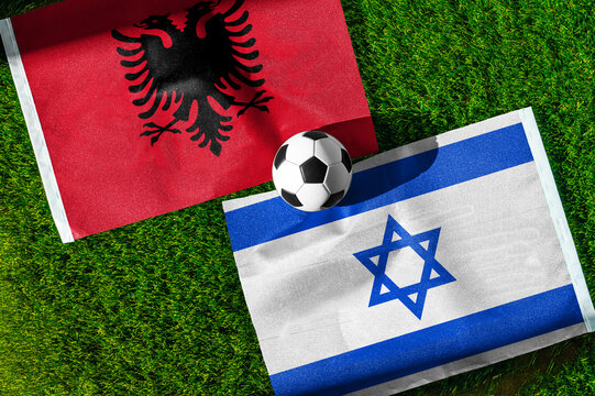 Albania vs. Israel football match. National flags on green grass with soccer ball in the middle. Football background for international match.