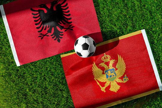 Albania vs. Montenegro football match. National flags on green grass with soccer ball in the middle. Football background for international match.