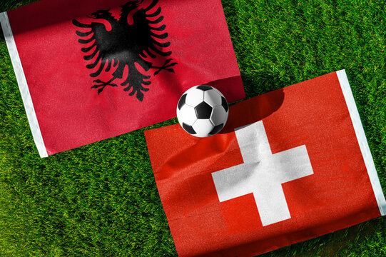 Albania vs. Switzerland football match. National flags on green grass with soccer ball in the middle. Football background for international match.