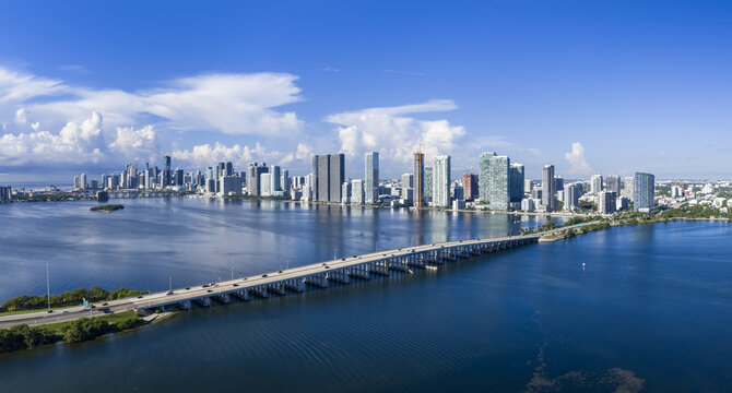 Aerial view of the Julia Tuttle Causeway crossing Biscayne Bay with the Miami skyline in the background under a clear blue sky, Miami, Florida, United States.