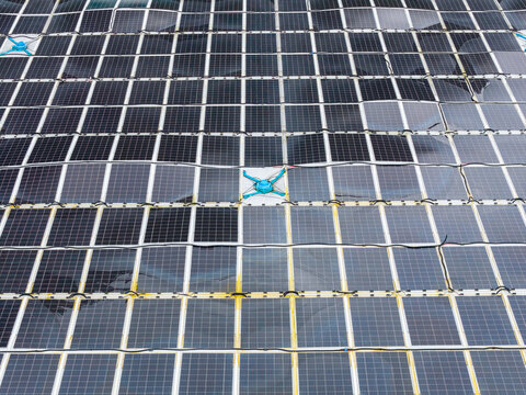 Aerial view of a circular floating solar power plant on the water surface, featuring interconnected photovoltaic panels and blue structural connectors in Liabygda, More og Romsdal, Norway.
