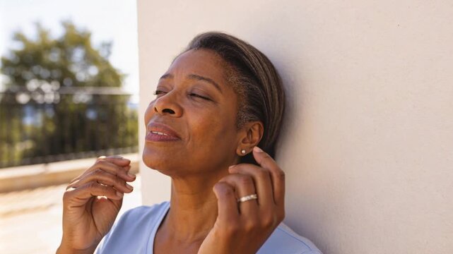 Leaning woman starting voicing emoting hand at throat tilting closing eyes on deck in blue-top ring