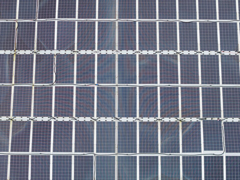 Aerial view of a circular floating solar power plant featuring a grid of photovoltaic panels on the water surface in Liabygda, More og Romsdal, Norway.