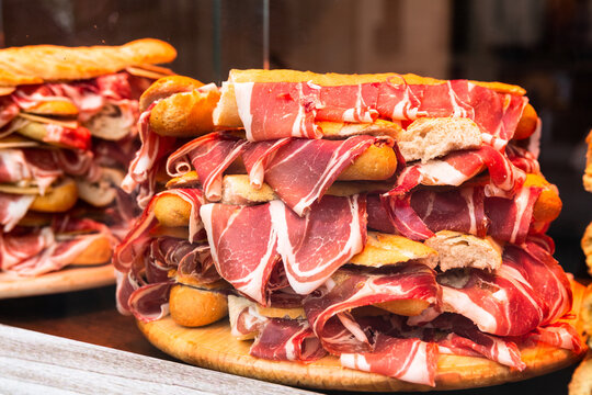 mouth watering sandwiches with jamon laid out in a slide on shop window
