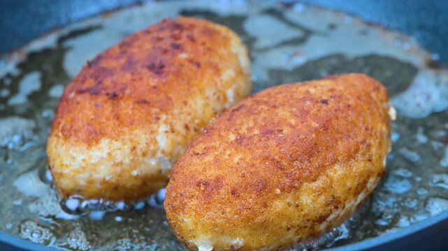 cordon bleu schnitzels filled with melted cheese frying