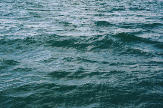 background with blue sea waves on water surface. Texture of the ocean waves.