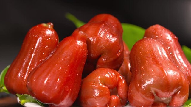 Fresh Red Wax Apples with Water Droplets and Green Leaves Close-Up