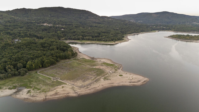 Aerial view of Aquis Querquennis Roman ruins situated on the banks of the As Conchas reservoir surrounded by dense forests in Porto-Quintela, Ourense, Spain.