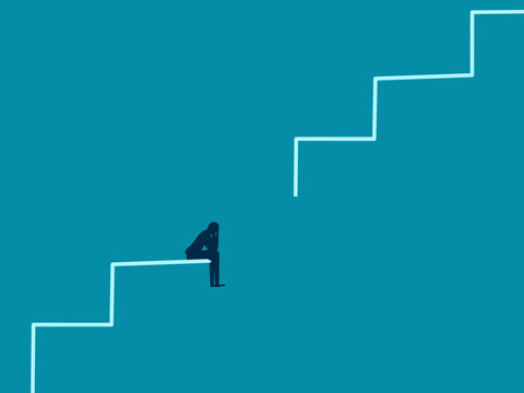 businessman sat dejectedly on the broken staircase