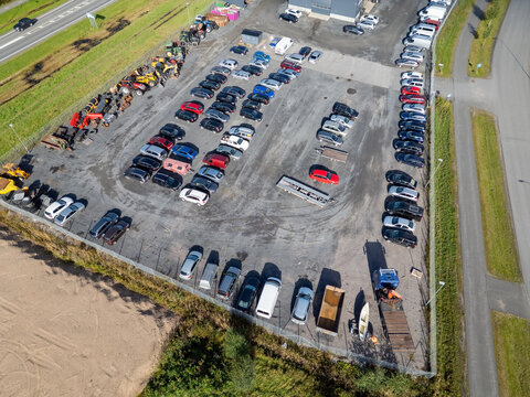 Aerial view of a used car dealer with rows of parked vehicles, trailers, and heavy machinery on a gravel lot in Kempele, North Ostrobothnia, Finland.