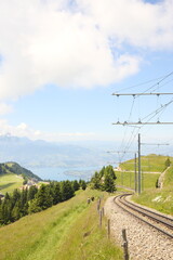 Obraz premium Railway tracks curving through green slopes in the Swiss Alps