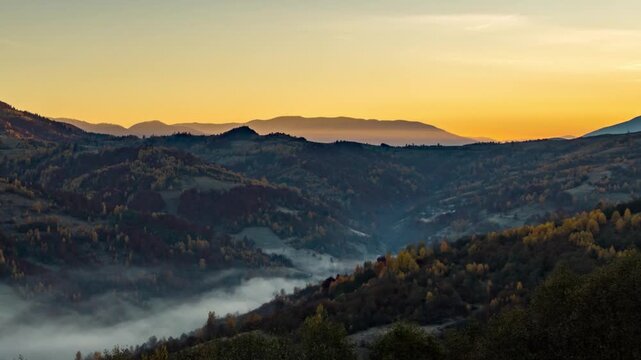 Sun rises in highland and morning fog fills valley in autumn
