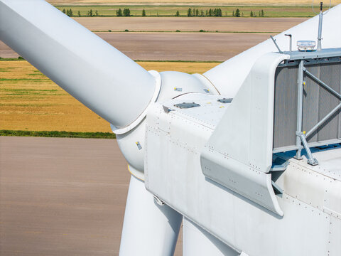 Aerial view of a wind turbine nacelle and blade assembly set against agricultural fields in Targale parish, Ventspils Municipality, Latvia.