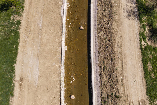 Aerial view of a river restoration site focused on channel widening and flood prevention in a rural area.