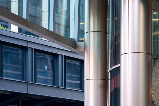 Metal columns and glass office facades where reflective surfaces and modern urban geometry shape the architecture across the glass facades and columns