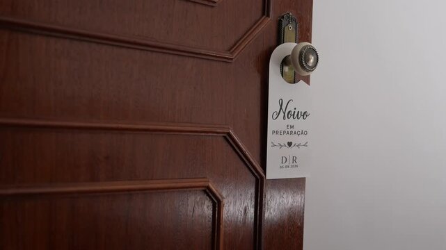 Door hanger reading Noivo em preparacao on rustic wooden door, groom getting ready sign for wedding day privacy and pre ceremony moments