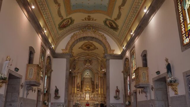 Ornate church interior showing the golden altar, religious statues, and a beautifully decorated ceiling, representing faith and history