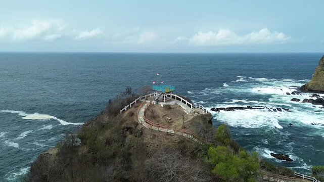 Scenic view of Papuma Beach with an iconic landmark nearby