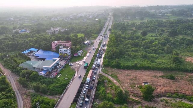 High altitude sweeping panoramic drone shot revealing a massive kilometers-long traffic queue caused by highway flyover construction and roadworks.