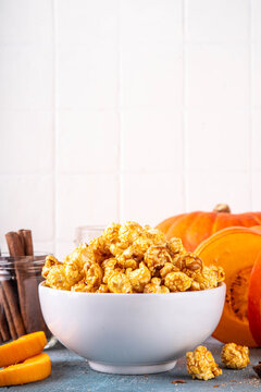 Pumpkin popcorn with caramel and pumpkin spice. Bowl with tasty sweet popcorn covered with pumpkin spice caramel, cinnamon and spices, copy space