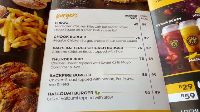 Close-up shot of a printed restaurant menu page featuring a selection of gourmet burgers, showcasing descriptive listings and pricing in a clean, appetizing layout.