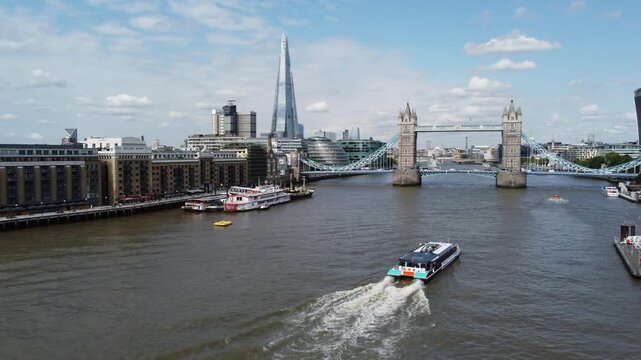 Uber boat by Thames clippers heading for Tower bridge London UK drone aerial
