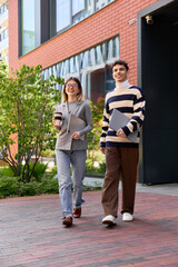 Fototapeta premium Young coworkers enjoy a sunny day outside their modern office building