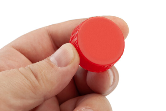Hand holding red plastic bottle cap