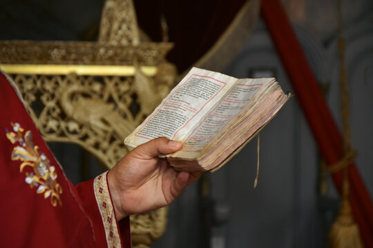 Priest reading from a Bible in an Orthodox church