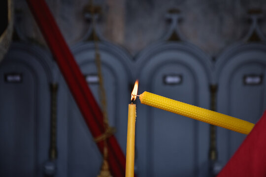 Closeup of a candle being lit in church