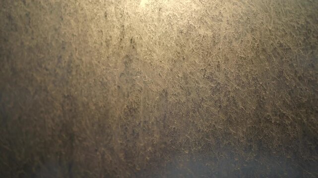 Abstract light streaks and textures moving slowly across grainy surface
