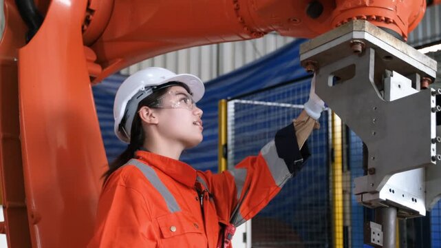Female engineers checking or maintenance electronic in AI Robot, robot arm in the manufacturing automation and robotics manufacture room.