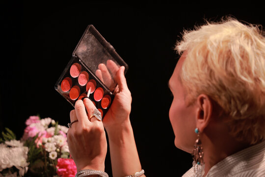 Experienced  feminine man  applies alternative makeup, achieving beautiful new look. Her focused expression reflects precision and artistry.
