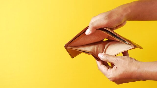 Man hands show empty wallet, financial struggle and poverty concept, demonstrating lack of money on yellow background, motion footage