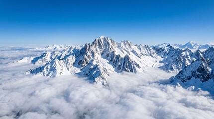 Fototapeta premium Overhead view of jagged mountain peaks covered in pristine snow piercing a thick layer of fluffy clouds into a brilliant clear blue sky.