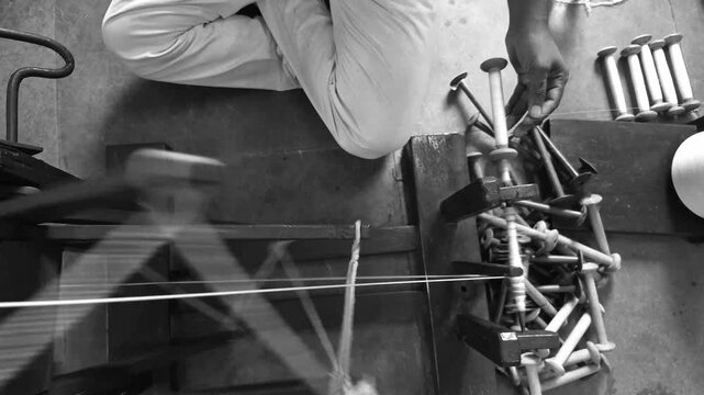 Handloom weaver preparing yarns in India.