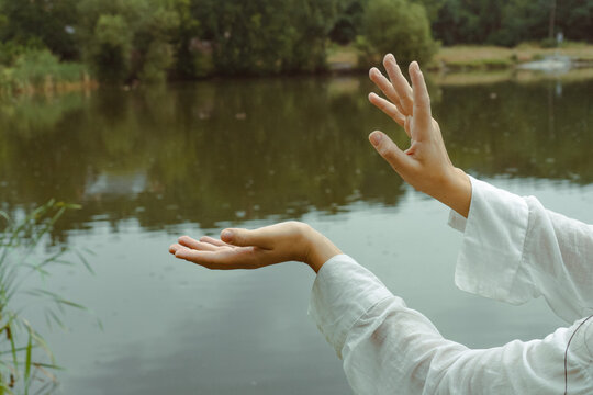 Beautiful girl's hands dancing on the background of the lake