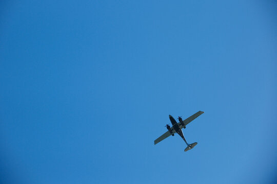 Twin-Engine Turboprop Airplane Flying in Clear Blue Sky