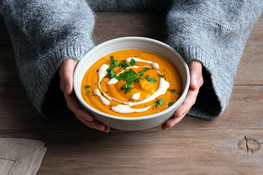 Bowl of red lentil soup in woman hands