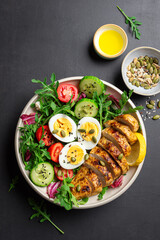 High protein lunch bowl with chicken, eggs and vegetable salad.