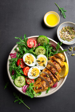 High protein lunch bowl with chicken, eggs and vegetable salad.