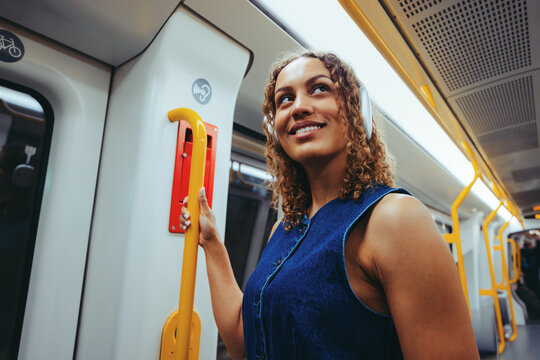 Woman on a train holding a handrail during commute