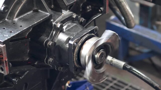 Panning shot of transmission rotating output flange and driveshaft yoke in test bench.