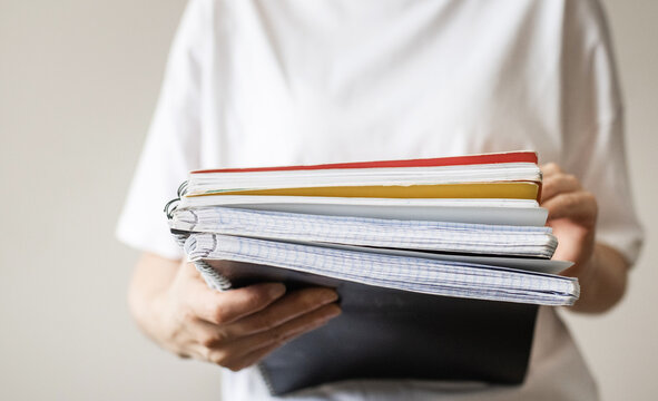Person holding notebooks and folders, person holding notebooks and folders, notebook theme, study theme, lifestyle theme